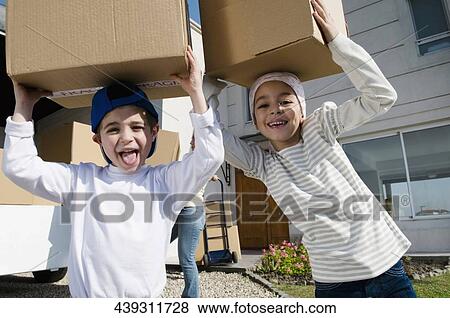 Portrait of a boy and a girl carrying cardboard boxes View Large Photo Image Stock Photo - Portrait of a boy and a girl carrying cardboard boxes. Fotosearch