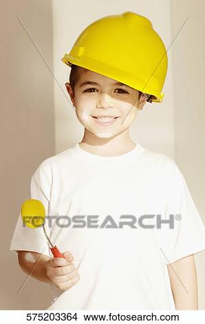 Portrait of a boy holding a paint roller View Large Photo Image Picture - Portrait of a boy holding a paint roller. Fotosearch