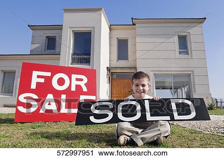 Portrait of a boy holding a sold signboard and smiling View Large Photo Image Stock Image - Portrait of a boy holding a sold signboard and smiling. Fotosearch