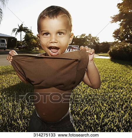 Stock Image - Portrait of a boy holding his t-shirt. Fotosearch
