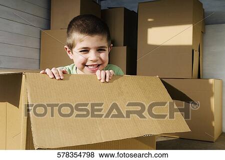 Portrait of a boy sitting in a cardboard box and smiling View Large Photo Image Stock Photo - Portrait of a boy sitting in a cardboard box and smiling. Fotosearch