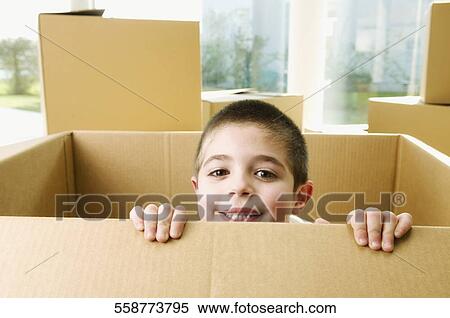 Stock Photography - Portrait of a boy smiling in a cardboard box. Fotosearch