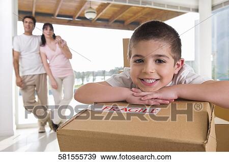 Stock Photo - Portrait of a boy smiling with his parents standing in the background. Fotosearch