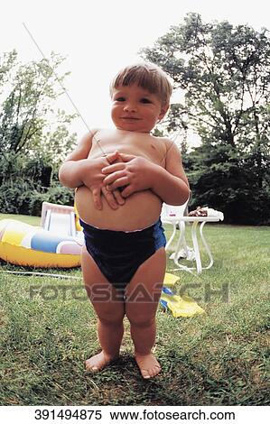 Portrait of a boy standing with his hands on his stomach View Large Photo Image Stock Photography - Portrait of a boy standing with his hands on his stomach. Fotosearch
