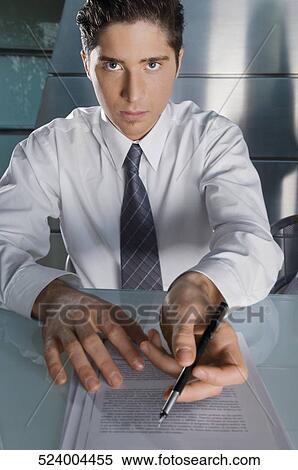 Portrait of a businessman giving documents and a pen View Large Photo Image Stock Photography - Portrait of a businessman giving documents and a pen. Fotosearch