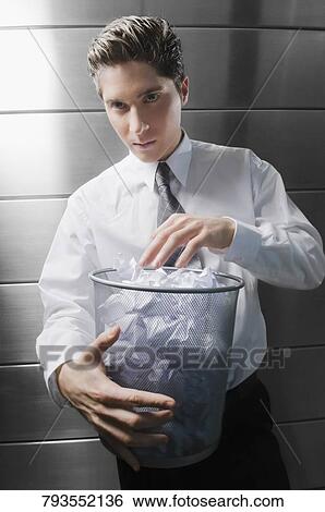 Portrait of a businessman holding a wastepaper basket View Large Photo Image Stock Photograph - Portrait of a businessman holding a wastepaper basket. Fotosearch