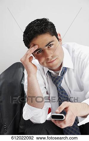 Portrait of a businessman operating a remote control View Large Photo Image Stock Image - Portrait of a businessman operating a remote control. Fotosearch