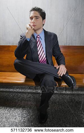 Stock Photograph - Portrait of a businessman sitting on a bench and thinking. Fotosearch