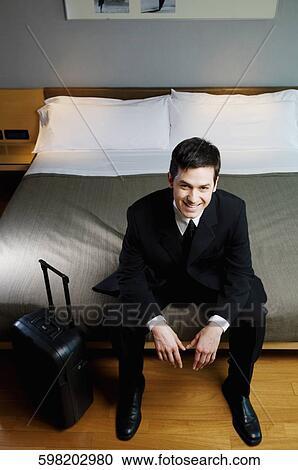 Portrait of a businessman sitting on the bed View Large Photo Image Stock Image - Portrait of a businessman sitting on the bed. Fotosearch