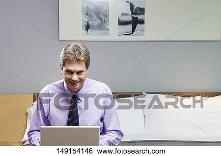 Portrait of a businessman working on a laptop View Large Photo Image Stock Photograph - Portrait of a businessman working on a laptop. Fotosearch