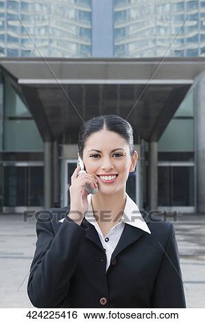 Portrait of a businesswoman talking on a mobile phone and smiling View Large Photo Image Stock Photograph - Portrait of a businesswoman talking on a mobile phone and smiling. Fotosearch