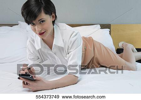 Stock Photo - Portrait of a businesswoman using a personal data assistant. Fotosearch