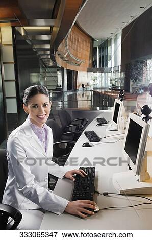 Portrait of a businesswoman working on a desktop PC and smiling View Large Photo Image Stock Photo - Portrait of a businesswoman working on a desktop PC and smiling. Fotosearch