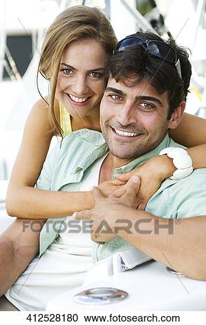 Stock Image - Portrait of a couple sitting in a ship and smiling. Fotosearch