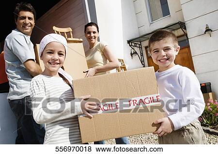 Portrait of a family carrying cardboard boxes and smiling View Large Photo Image Stock Photo - Portrait of a family carrying cardboard boxes and smiling. Fotosearch