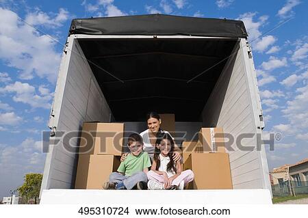 Picture - Portrait of a family sitting in a truck and smiling. Fotosearch