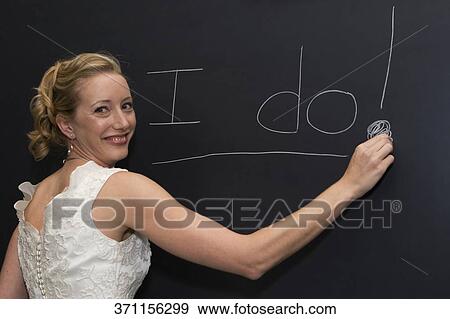 Portrait of a female teacher writing on a blackboard and smiling View Large Photo Image Stock Photo - Portrait of a female teacher writing on a blackboard and smiling. Fotosearch