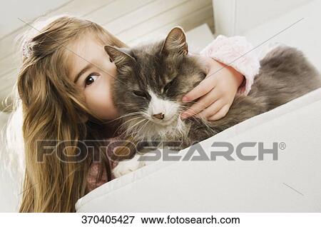 Portrait of a girl kissing a cat View Large Photo Image Stock Photo - Portrait of a girl kissing a cat. Fotosearch