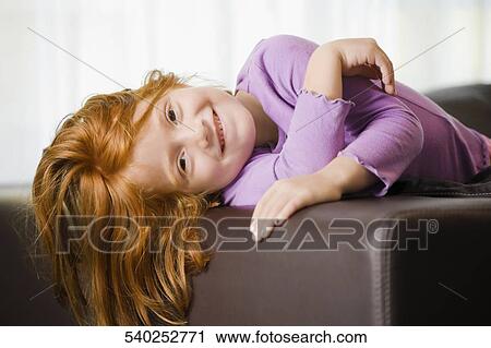 Portrait of a girl lying on the couch and smiling View Large Photo Image Stock Image - Portrait of a girl lying on the couch and smiling. Fotosearch