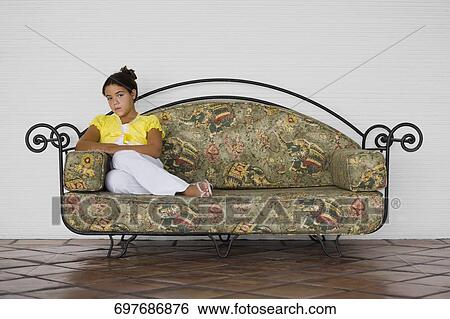 Portrait of a girl sitting on the couch View Large Photo Image Stock Photograph - Portrait of a girl sitting on the couch. Fotosearch