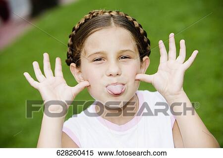 Portrait of a girl sticking out her tongue View Large Photo Image Stock Photography - Portrait of a girl sticking out her tongue. Fotosearch