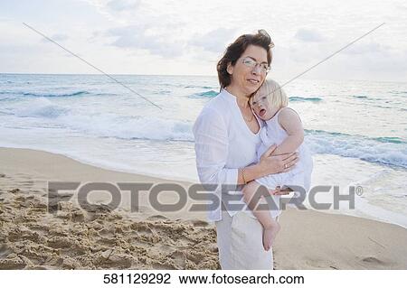 Portrait of a mature woman carrying her granddaughter View Large Photo Image Stock Image - Portrait of a mature woman carrying her granddaughter. Fotosearch