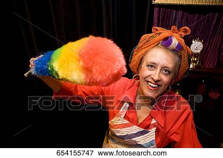 Portrait of a mature woman holding a duster and smiling View Large Photo Image Stock Photo - Portrait of a mature woman holding a duster and smiling. Fotosearch
