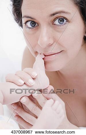 Portrait of a mature woman holding her baby's legs View Large Photo Image Stock Photo - Portrait of a mature woman holding her baby's legs. Fotosearch