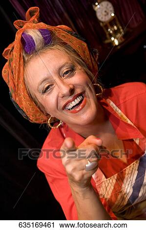 Stock Image - Portrait of a mature woman pointing and smiling. Fotosearch