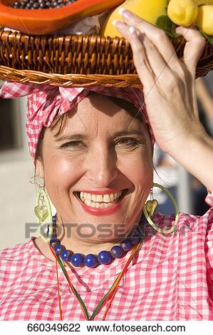 Stock Image - Portrait of a mature woman selling fruits. Fotosearch