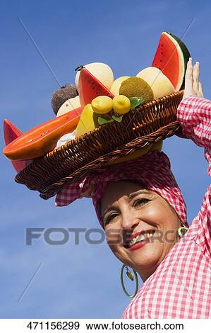 Stock Photo - Portrait of a mature woman selling fruits. Fotosearch