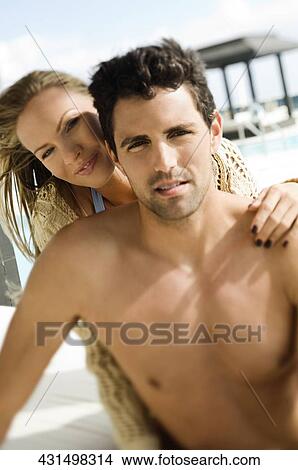 Portrait of a mid adult couple romancing at the poolside View Large Photo Image Picture - Portrait of a mid adult couple romancing at the poolside. Fotosearch