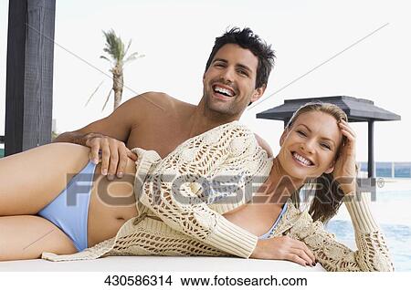 Portrait of a mid adult couple resting at the poolside View Large Photo Image Picture - Portrait of a mid adult couple resting at the poolside. Fotosearch