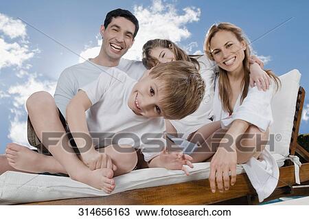 Portrait of a mid adult couple smiling with their children View Large Photo Image Stock Image - Portrait of a mid adult couple smiling with their children. Fotosearch