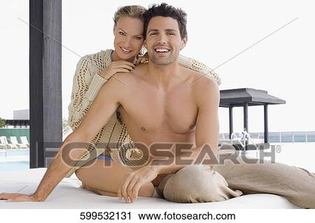 Portrait of a mid adult couple smiling at the poolside View Large Photo Image Stock Image - Portrait of a mid adult couple smiling at the poolside. Fotosearch