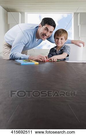 Portrait of a mid adult man assisting his son in his homework View Large Photo Image Stock Image - Portrait of a mid adult man assisting his son in his homework. Fotosearch