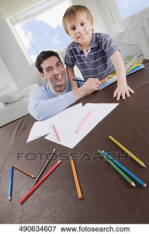 Portrait of a mid adult man assisting his son in his homework View Large Photo Image Stock Photo - Portrait of a mid adult man assisting his son in his homework. Fotosearch