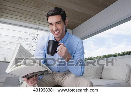 Portrait of a mid adult man holding a book and drinking coffee View Large Photo Image Stock Image - Portrait of a mid adult man holding a book and drinking coffee. Fotosearch