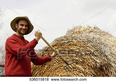 Portrait of a mid adult man holding a pitchfork View Large Photo Image Stock Photo - Portrait of a mid adult man holding a pitchfork. Fotosearch