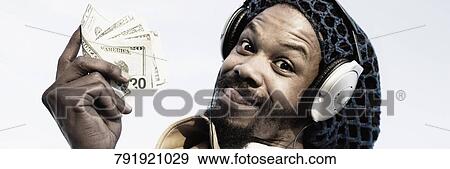 Portrait of a mid adult man listening to music and holding banknotes View Large Photo Image Stock Photo - Portrait of a mid adult man listening to music and holding banknotes. Fotosearch