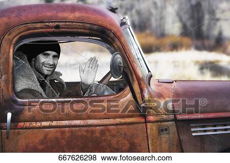 Portrait of a mid adult man sitting in a truck and waving his hand, Ghost Town, Virginia City, Montana, USA View Large Photo Image Stock Photo - Portrait of a mid adult man sitting in a truck and waving his hand, Ghost Town, Virginia City, Montana, USA. Fotosearch