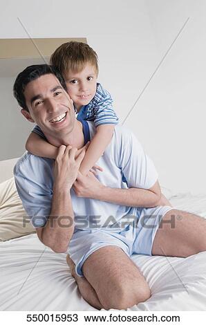 Portrait of a mid adult man smiling with his son View Large Photo Image Stock Image - Portrait of a mid adult man smiling with his son. Fotosearch