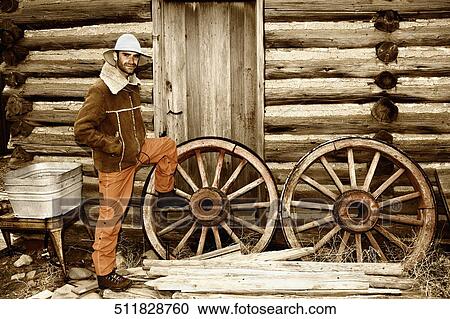 Portrait of a mid adult man standing near wagon wheels, Old Trail Town, Cody, Wyoming, USA View Large Photo Image Stock Image - Portrait of a mid adult man standing near wagon wheels, Old Trail Town, Cody, Wyoming, USA. Fotosearch