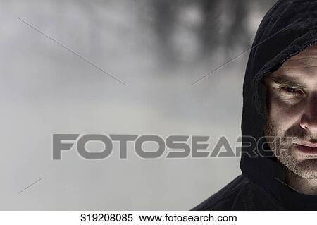 Portrait of a mid adult man wearing a hooded shirt and looking serious View Large Photo Image Stock Photography - Portrait of a mid adult man wearing a hooded shirt and looking serious. Fotosearch