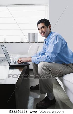 Portrait of a mid adult man working on a laptop View Large Photo Image Stock Photo - Portrait of a mid adult man working on a laptop. Fotosearch