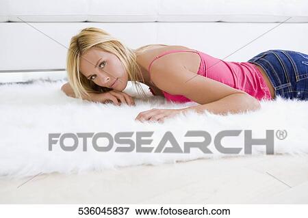 Portrait of a mid adult woman lying on rug View Large Photo Image Stock Photo - Portrait of a mid adult woman lying on rug. Fotosearch