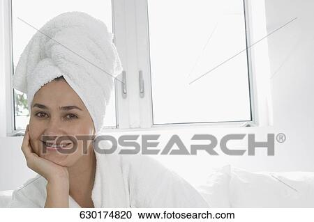 Stock Image - Portrait of a mid adult woman smiling in a bathrobe. Fotosearch