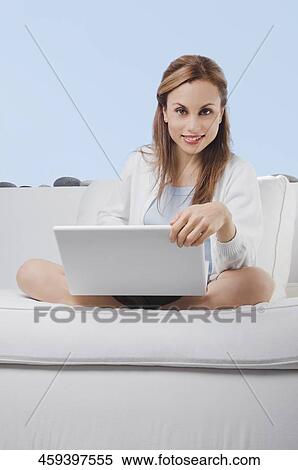 Portrait of a mid adult woman working on a laptop and smiling View Large Photo Image Stock Photography - Portrait of a mid adult woman working on a laptop and smiling. Fotosearch