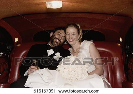 Portrait of a newlywed couple sitting in a car and smiling View Large Photo Image Stock Image - Portrait of a newlywed couple sitting in a car and smiling. Fotosearch