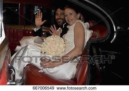 Portrait of a newlywed couple sitting in a car and waving hands View Large Photo Image Stock Photo - Portrait of a newlywed couple sitting in a car and waving hands. Fotosearch